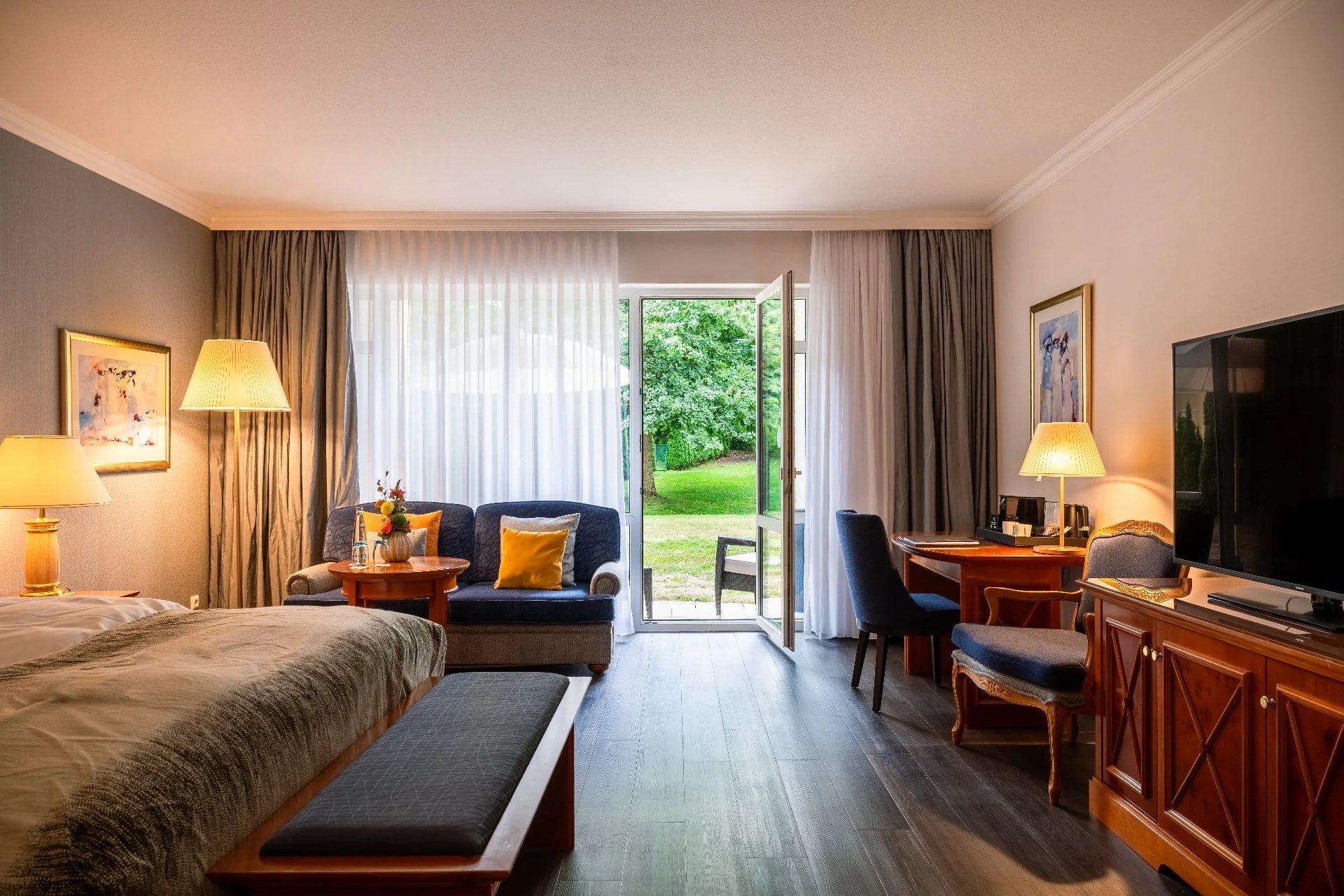 Deluxe-Zimmer im Steigenberger Hotel Der Sonnenhof mit offener Tür zum Garten